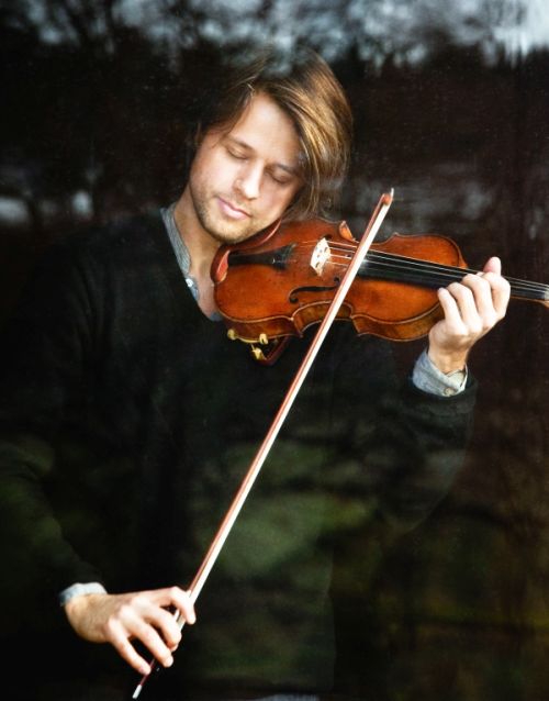 mężczyzna z przymkniętymi oczami, grający na skrzypcach