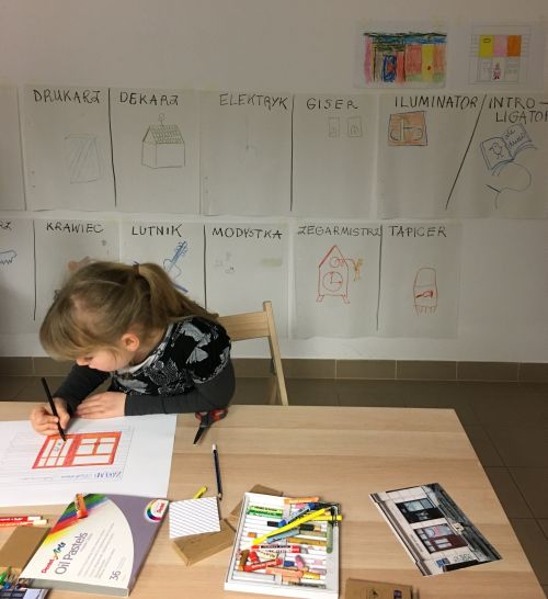 dziewczynka rysuje kolorowo na kartce